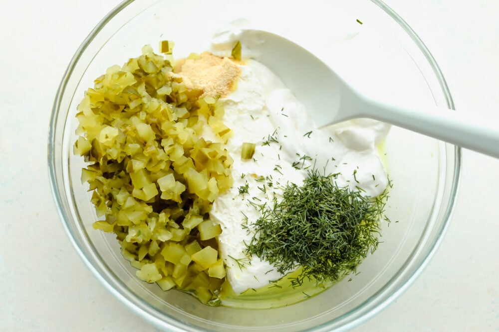 Dill pickle dip ingredients in a glass bowl.