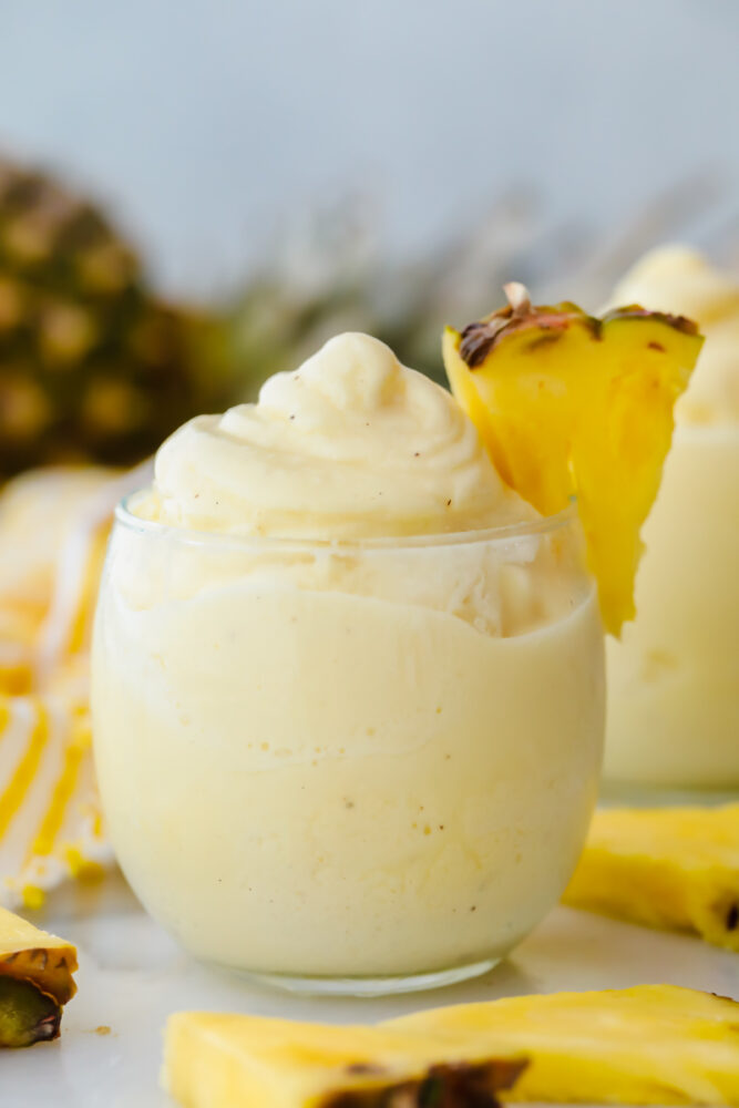 Dole pineapple whip in a glass with fresh pineapple garnish. 