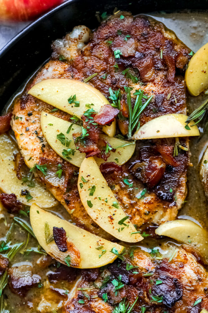 A pork chop with apples in a bacon sauce. 