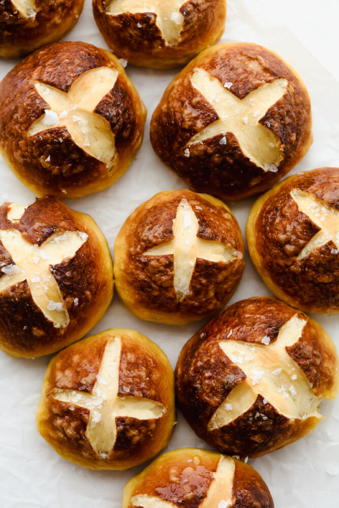 Pretzel Rolls with coarse salt on parchment paper.