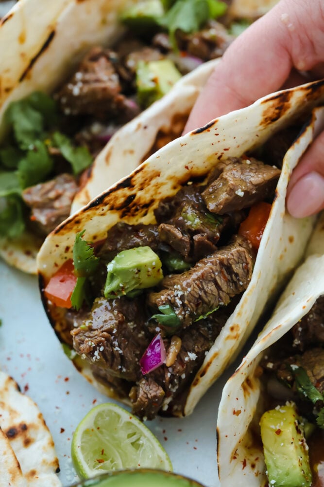 A taco folded up being held and ready to eat. 