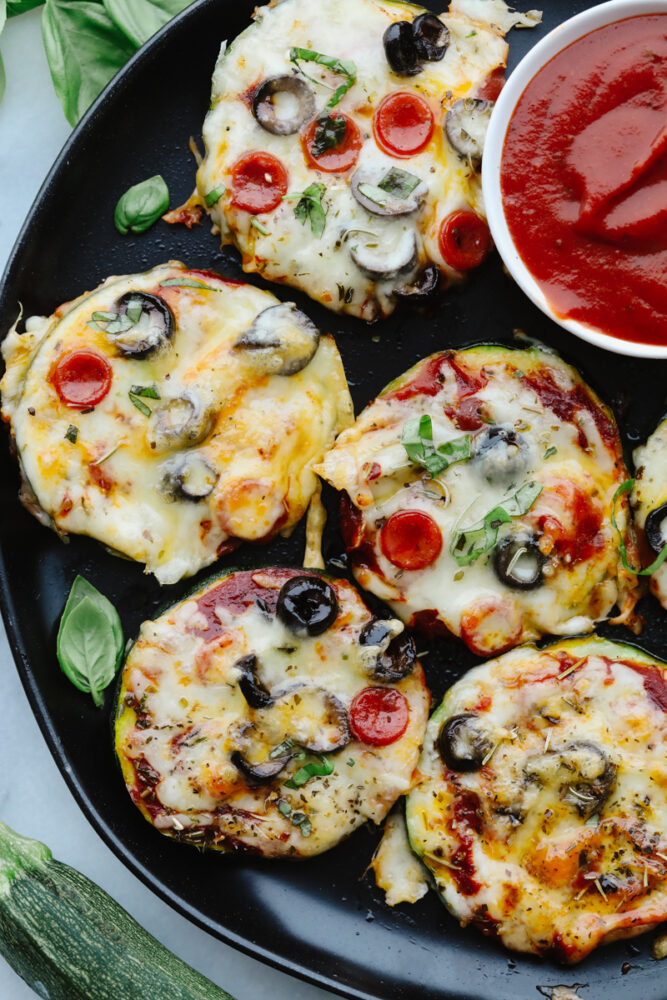 Pizza bites on a plate with a side of marinara. 