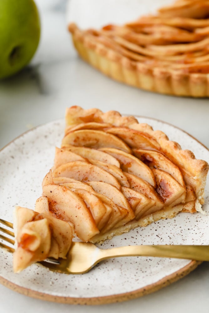 Taking a bite of an apple tart slice.