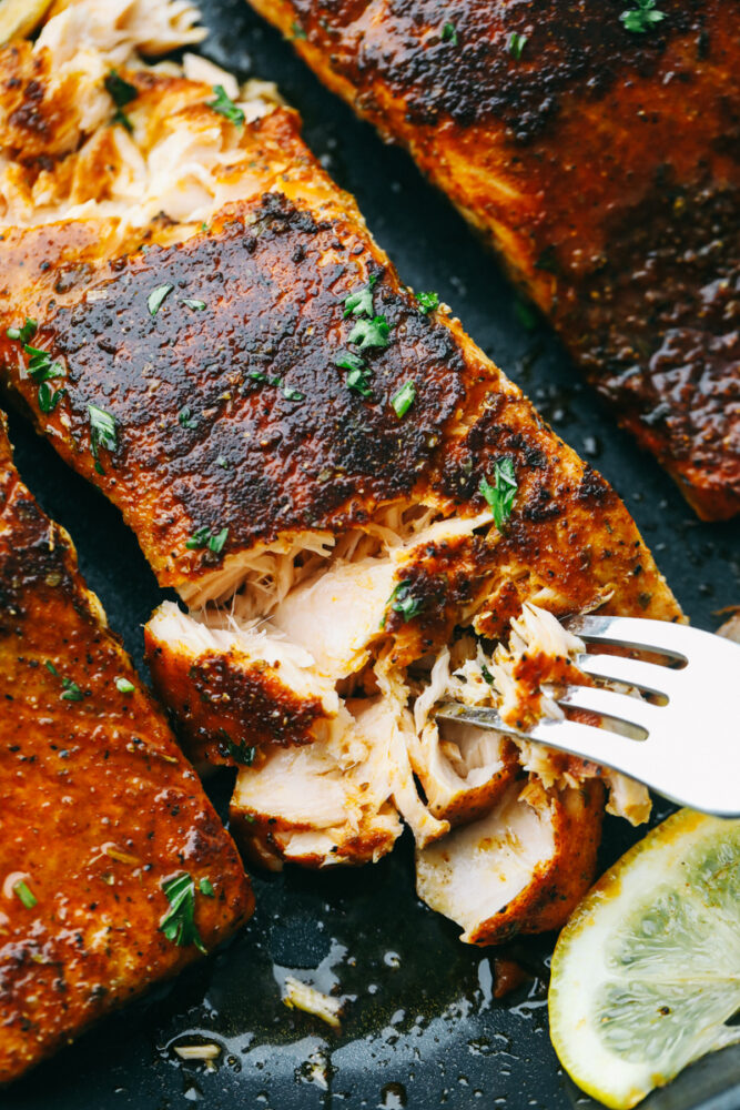 Flaking of tender bites of salmon with a fork. 