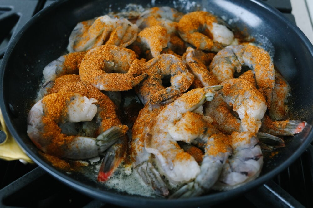 Uncooked shrimp sprinkled with seasoning. 