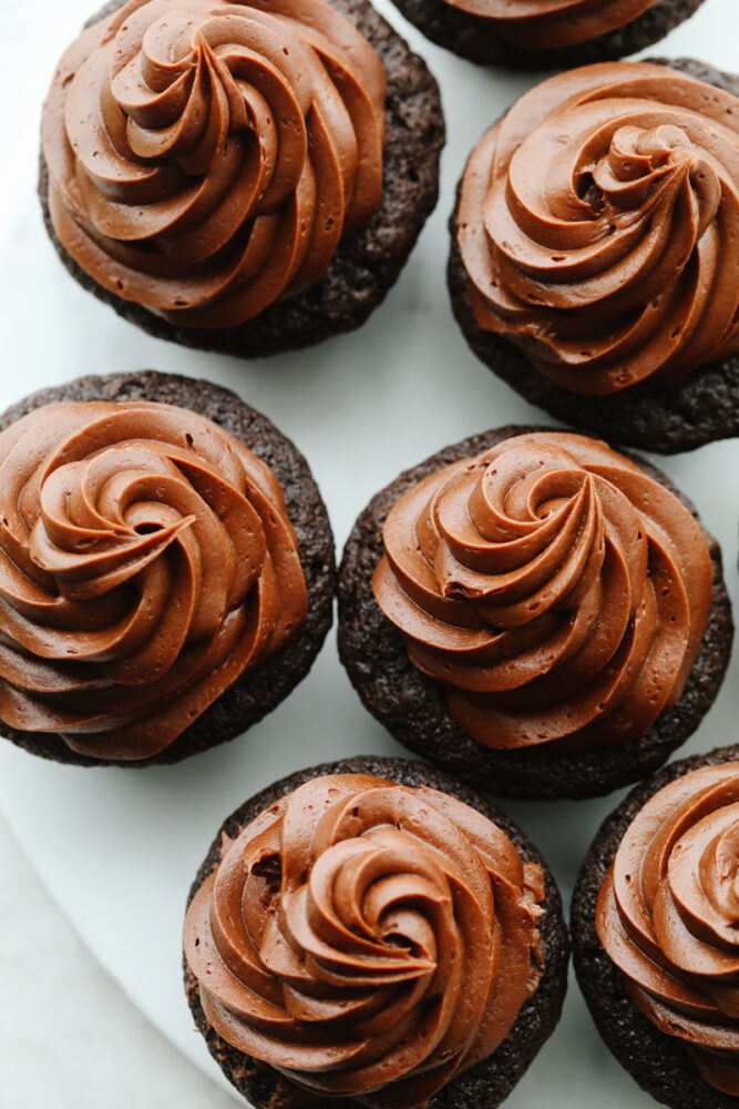 Chocolate buttercream frosting on top of chocolate cupcakes. 