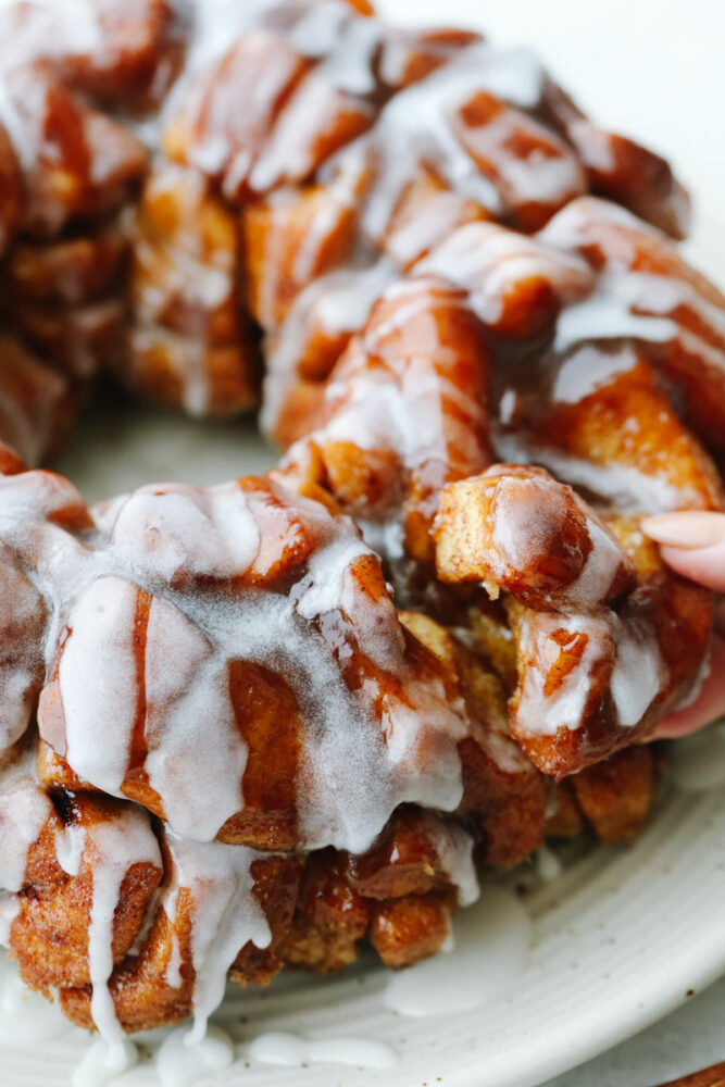 Closeup of taking a piece of cinnamon roll monkey bread.