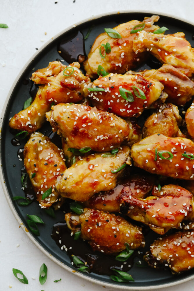 Buffalo wings drizzled in sauce on a platter. 