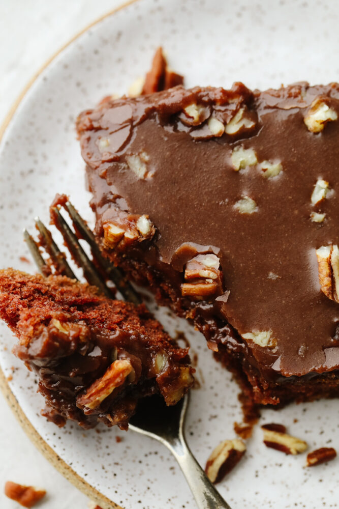 Sheet cake on a plate being cut with a fork. 