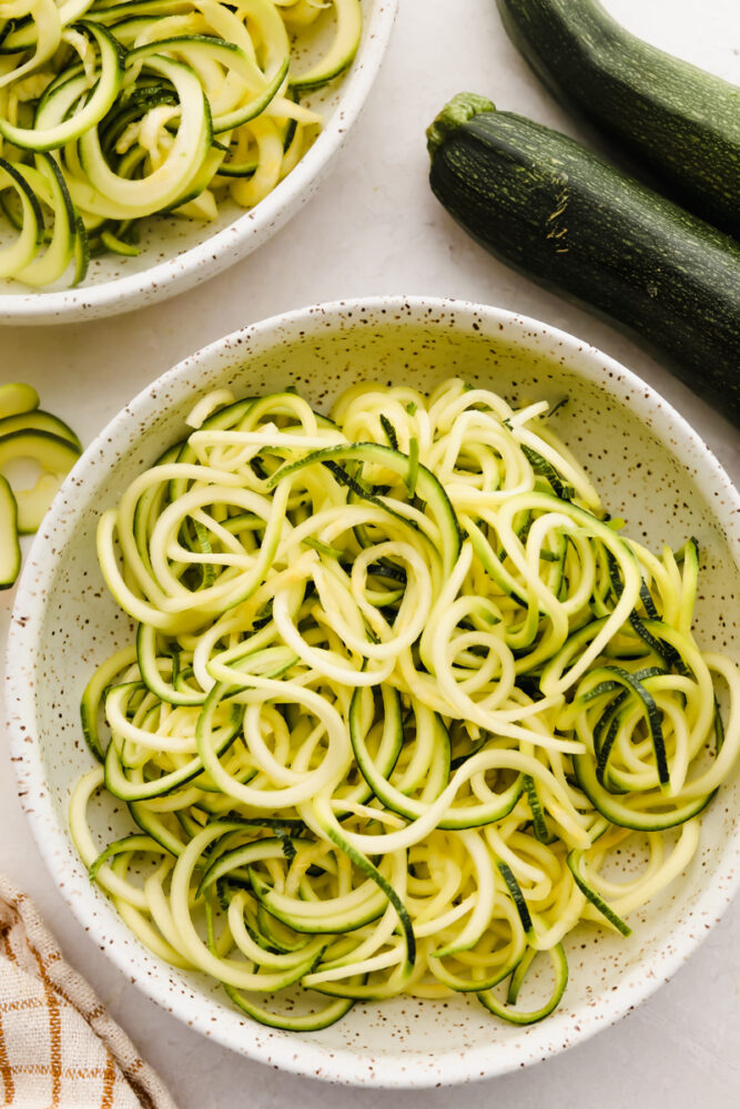 Raw grated zucchini in a bowl.