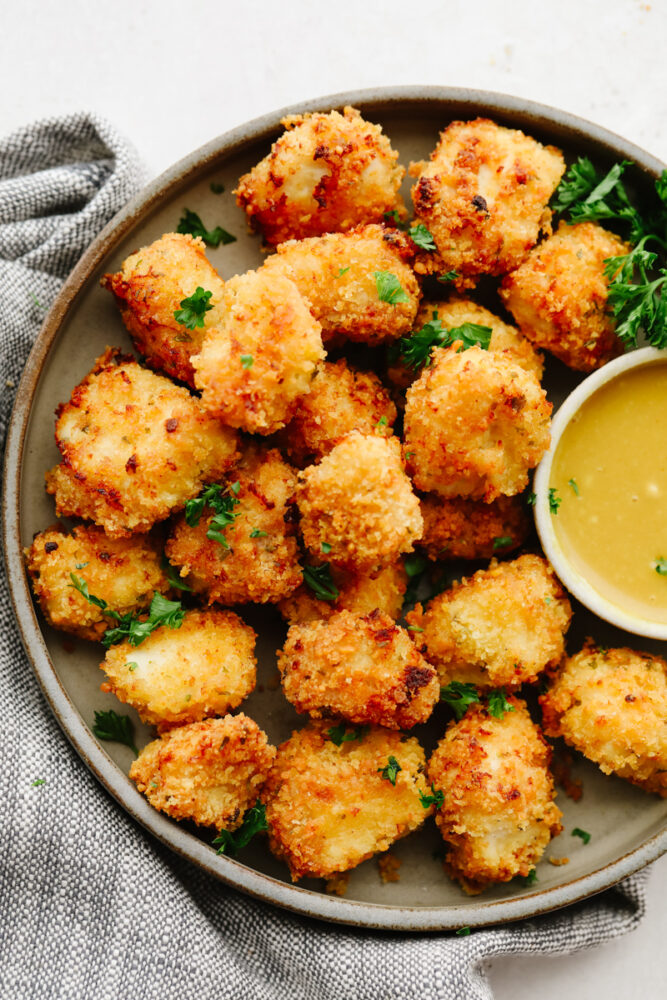 Chicken nuggets on a tray with honey mustard sauce. 