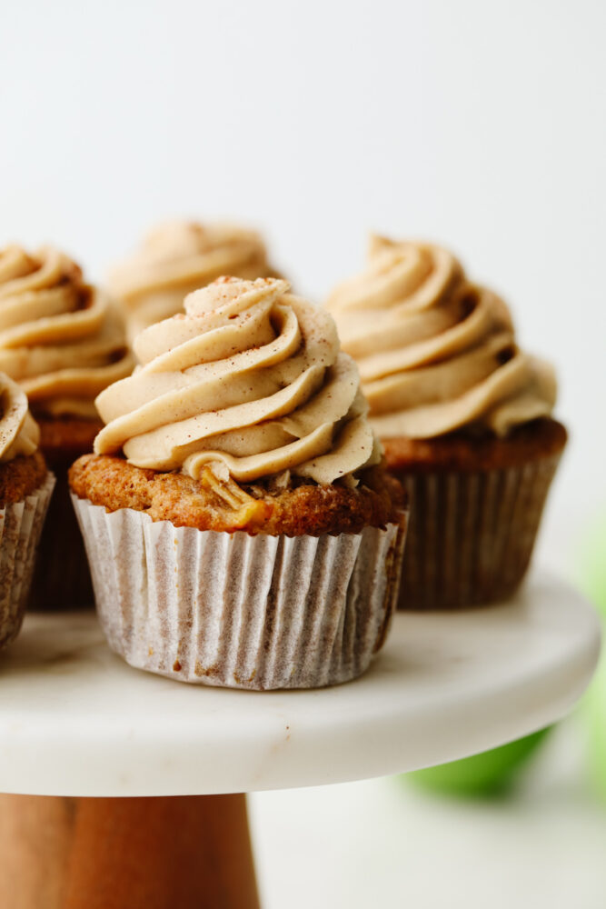 Close up of an apple pie cupcake on a cake stand. 