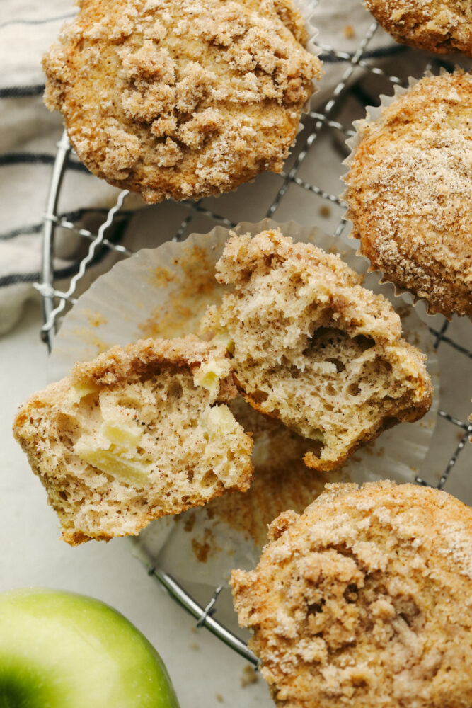 A muffin torn into 2 pieces on a wire rack.