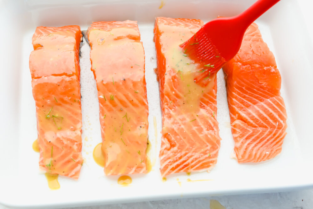 Salmon filets being basted before being cooked. 