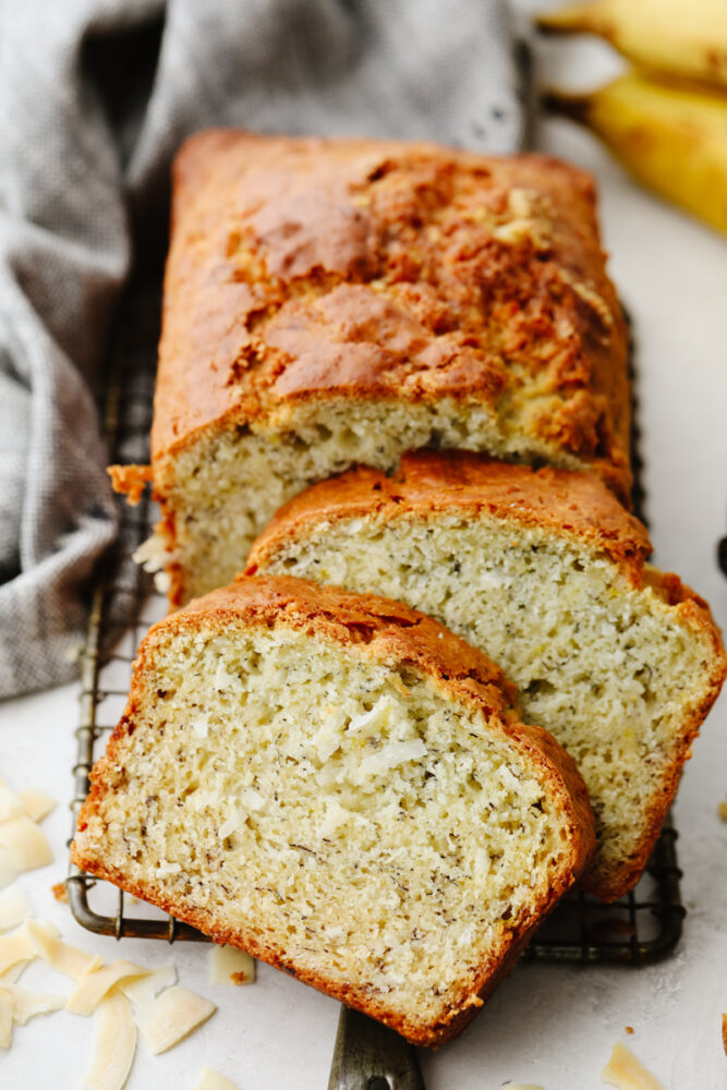 Sliced coconut banana bread on a cooling rack. 