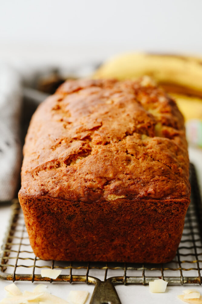 A loaf of bread on a cooling rack. 