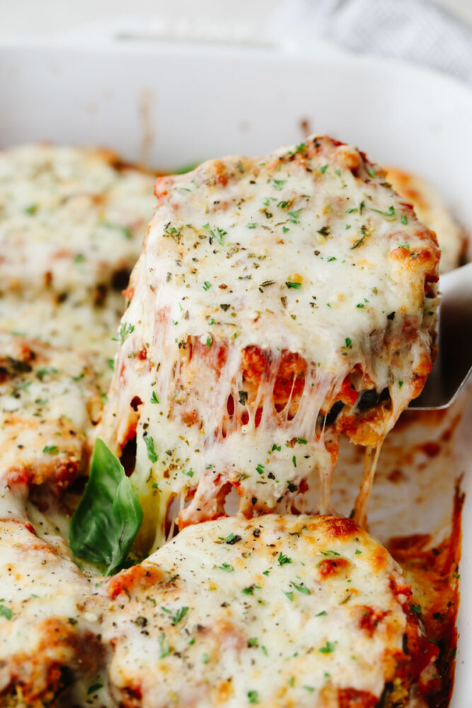 Eggplant parmesan being dished up. 