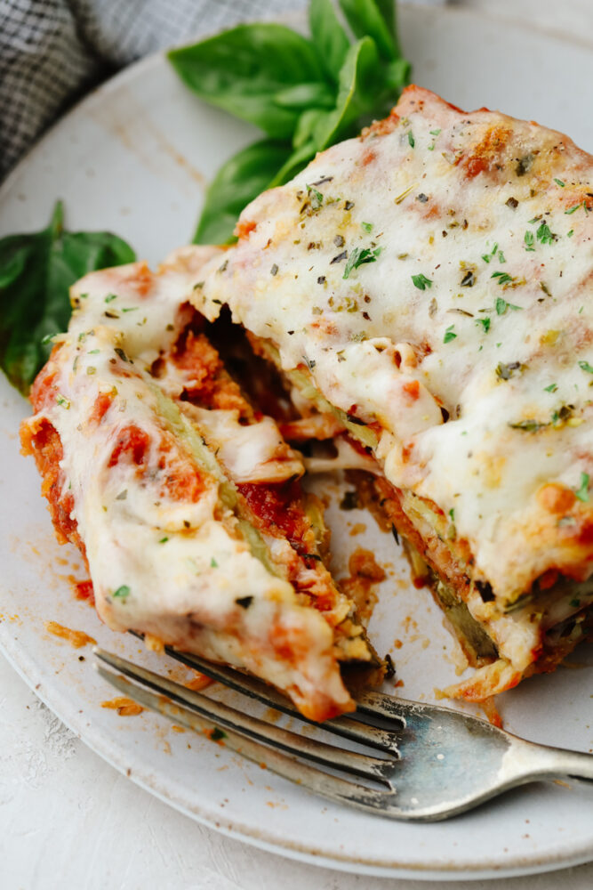 Eggplant parmesan being cut into with a fork. 