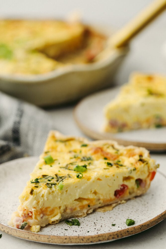 A quiche slice on a stoneware dish.