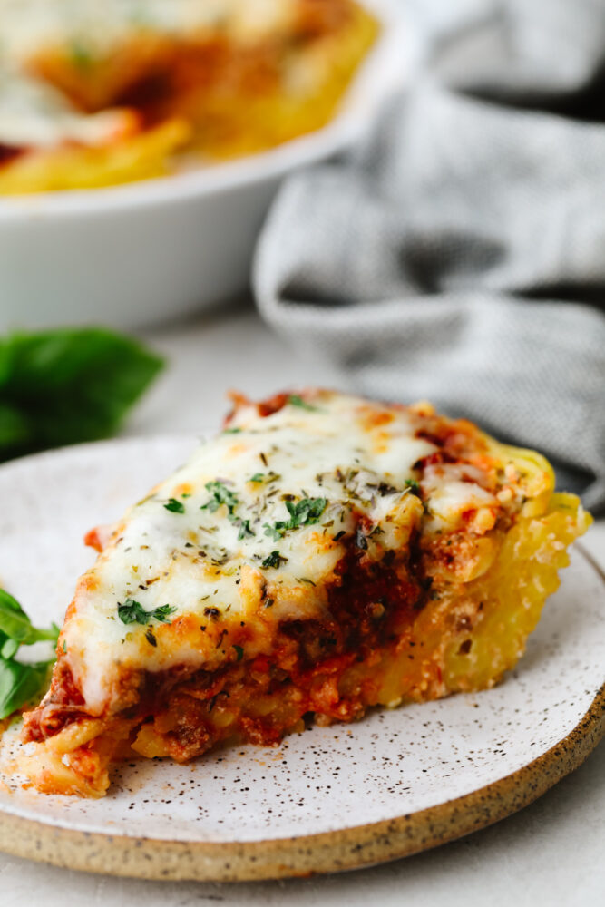 A slice of spaghetti pie on a stoneware dish.