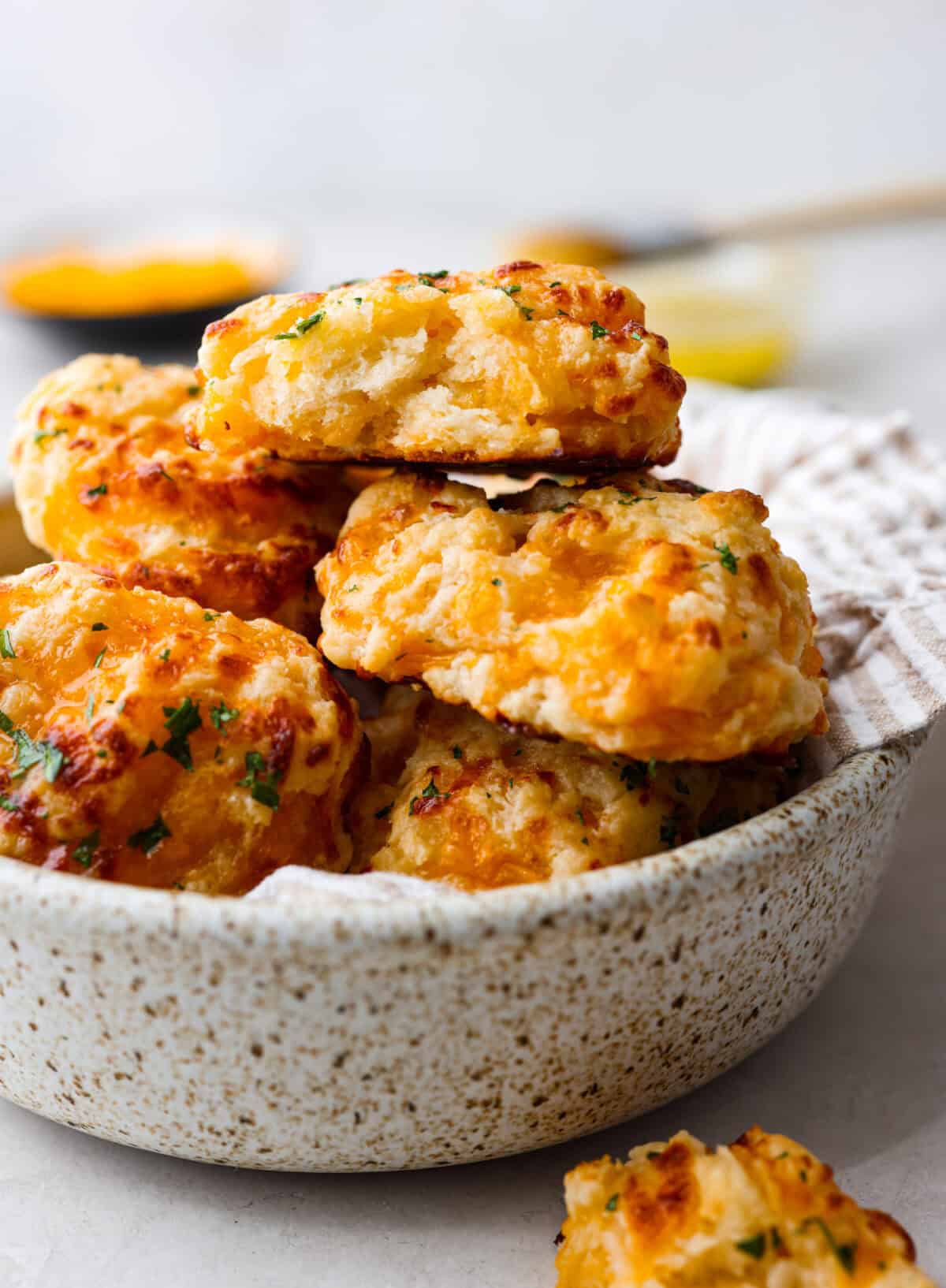 Close view of red lobster cheddar bay biscuits stacked in a serving bowl.