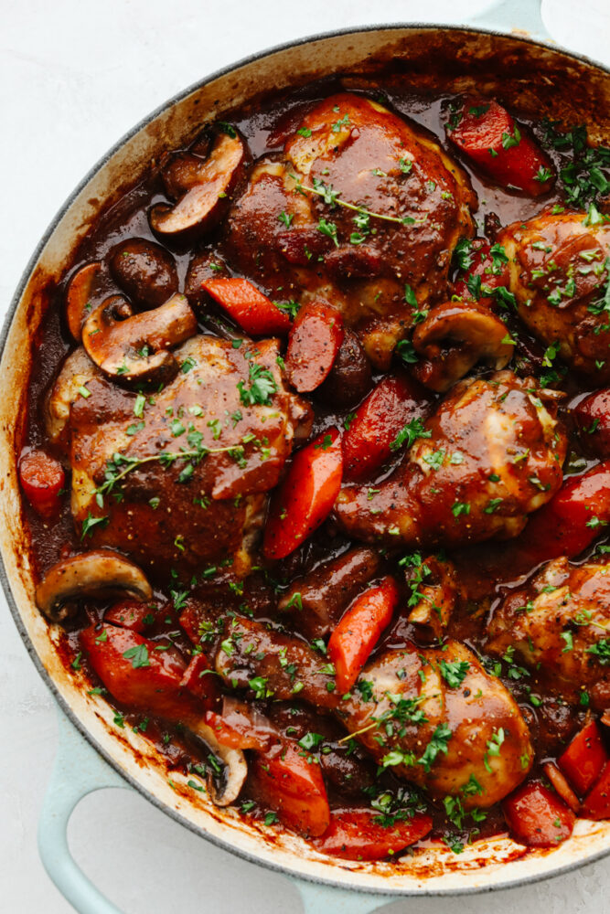 Garnish coq au vin in a pan. 