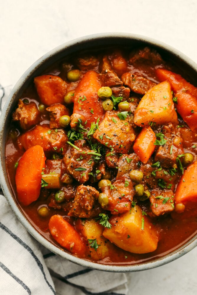 Beef stew garnished and in a bowl. 