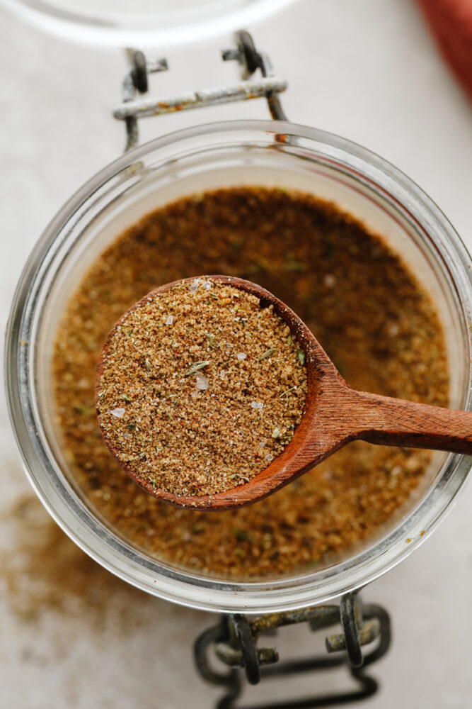 Jerk seasoning being scooped with a wooden spoon. 