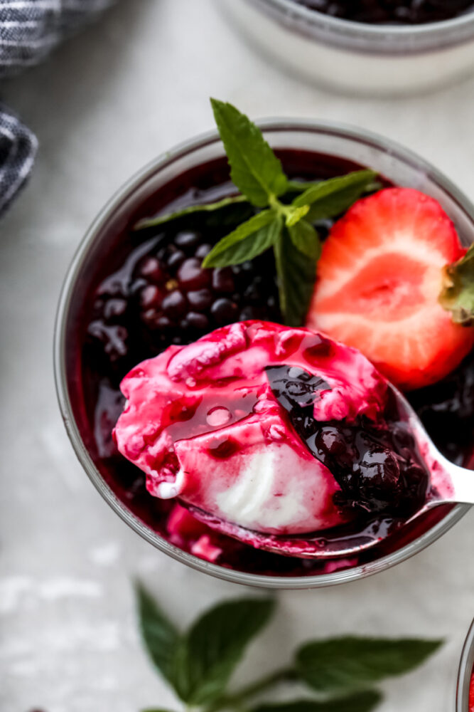 A spoon dipping into panna cotta. 