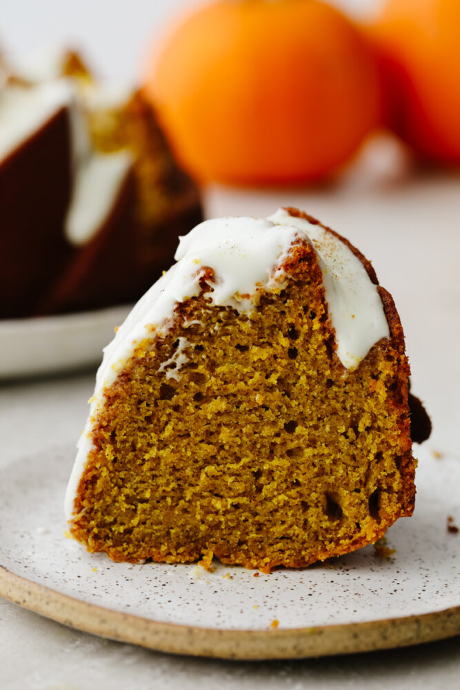 Slice of pumpkin bundt cake with frosting. 