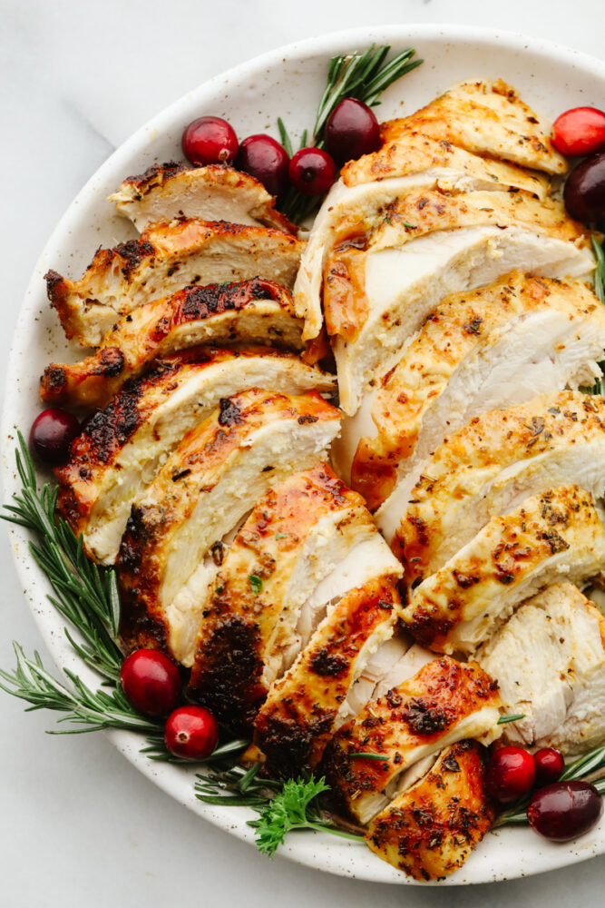 Sliced turkey on a plate with garnish. 