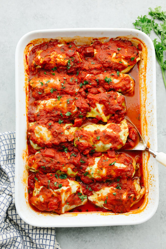 A casserole dish filled with cooked cabbage rolls. 