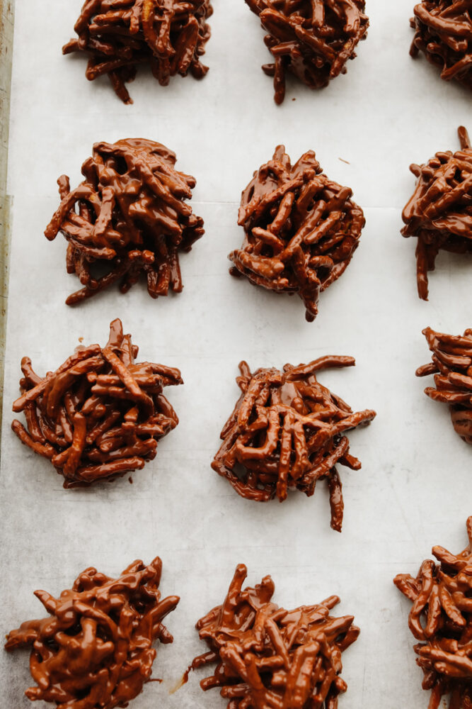 Chocolate haystack cookies on parchment paper on a baking sheet. 