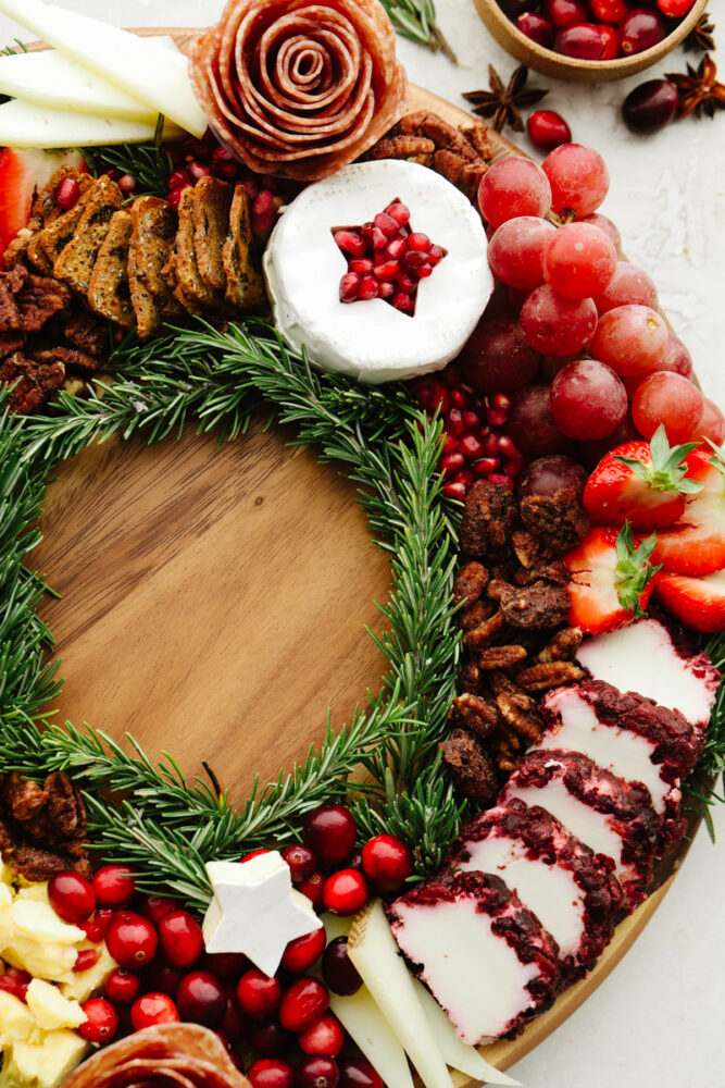 A close up of the side of the charcuterie board with nuts, cheeses and cranberries. 