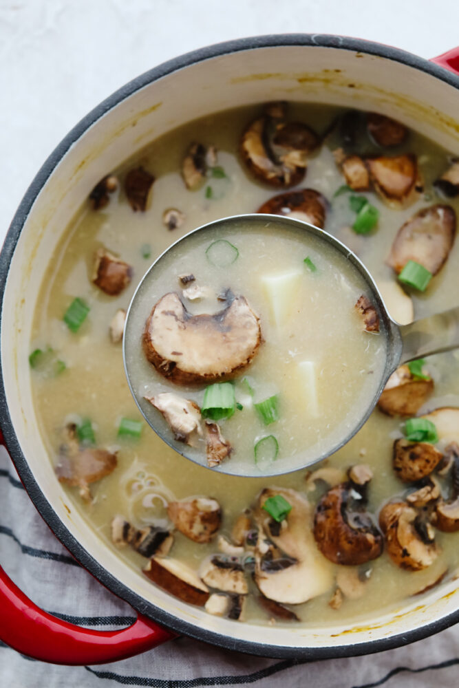 Hot and sour soup being served with a ladel. 