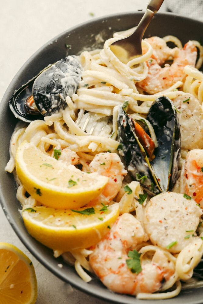 Seafood pasta in a bowl with a fork in the bowl. 