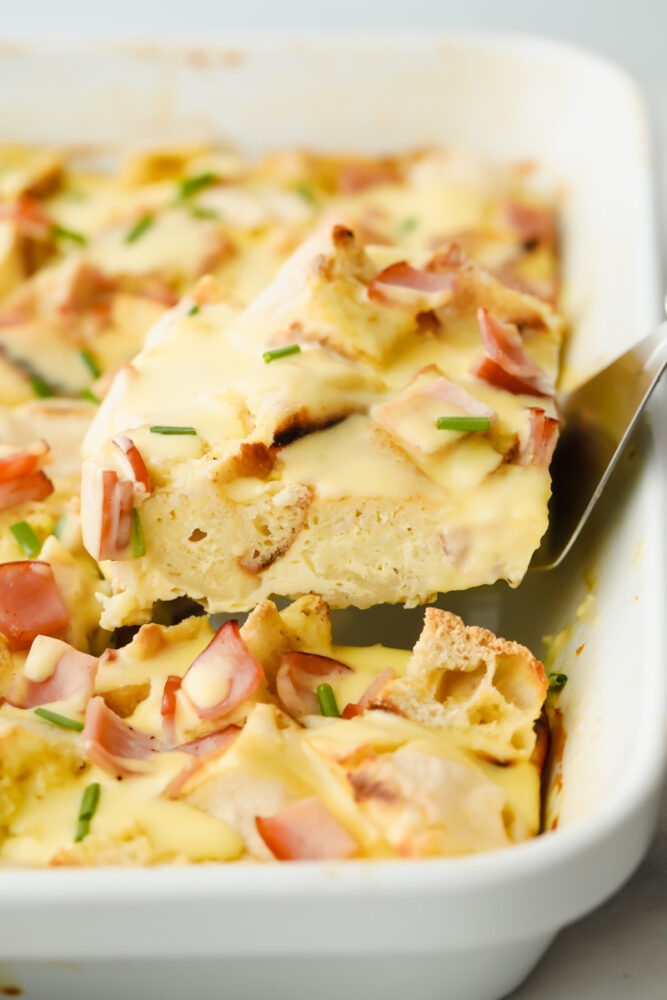 Taking a slice of casserole out of the pan.