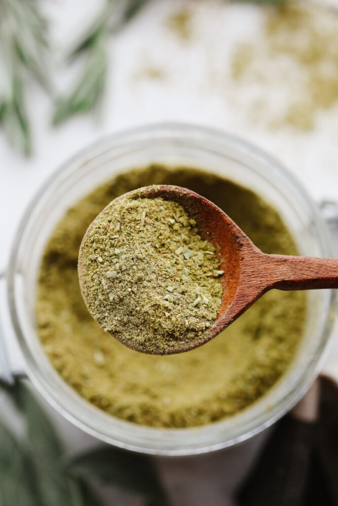 Closeup of poultry seasoning in a wooden spoon.