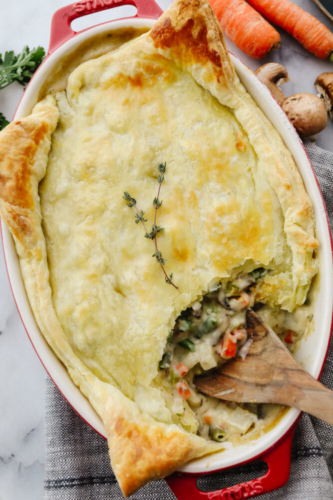 Scooping out vegetarian pot pie with a wooden spoon.