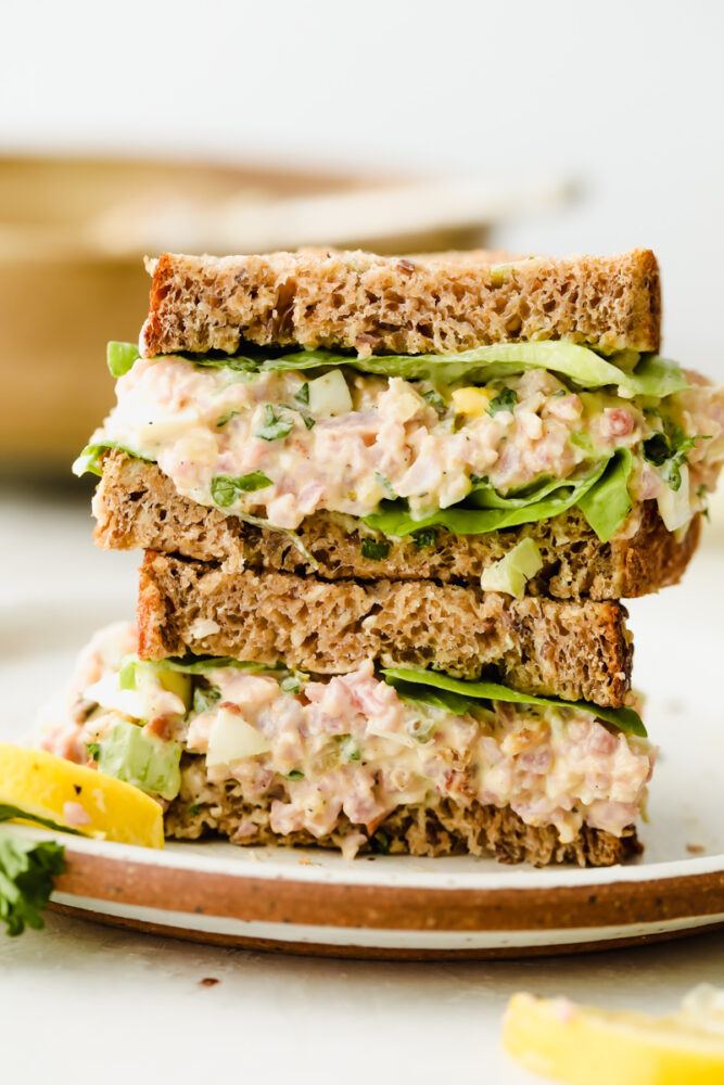 A ham salad sandwich on a plate stacked 2 high. 