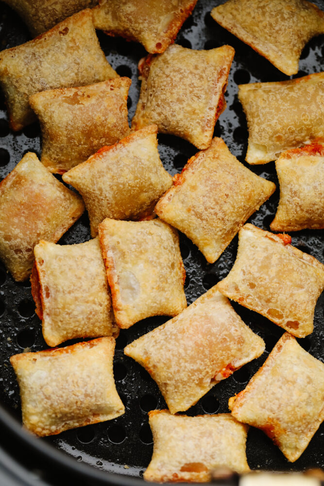 Pizza rolls in an air fryer basket. 