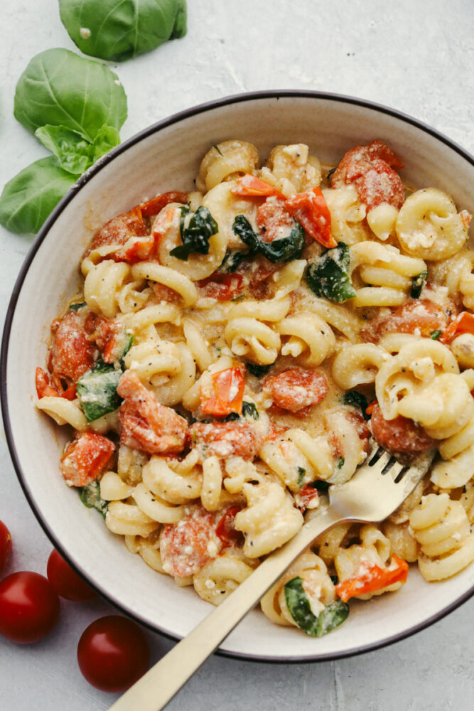 Baked feta pasta in a bowl with a gold fork. 