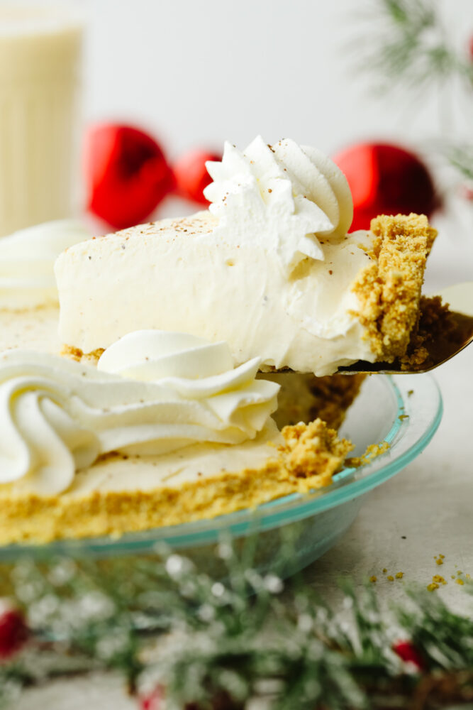 A slice of pie being taken out of the pie pan. 