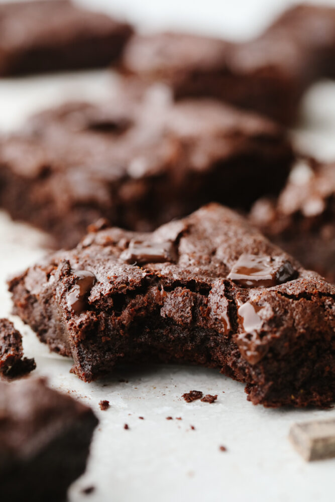 A flourless chocolate brownie with a bite taken out of it. 