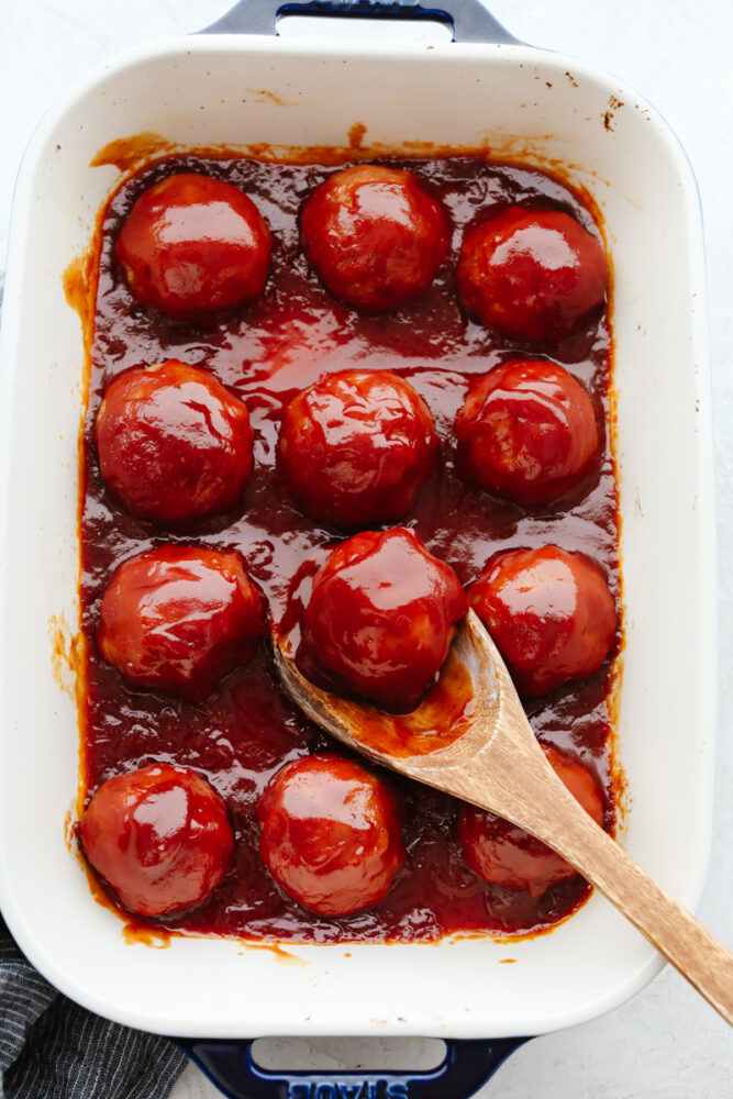 12 meatballs in a white casserole dish.