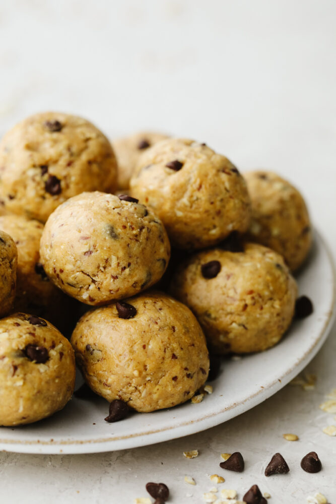 A white plate stacked with chocolate chip protein balls.