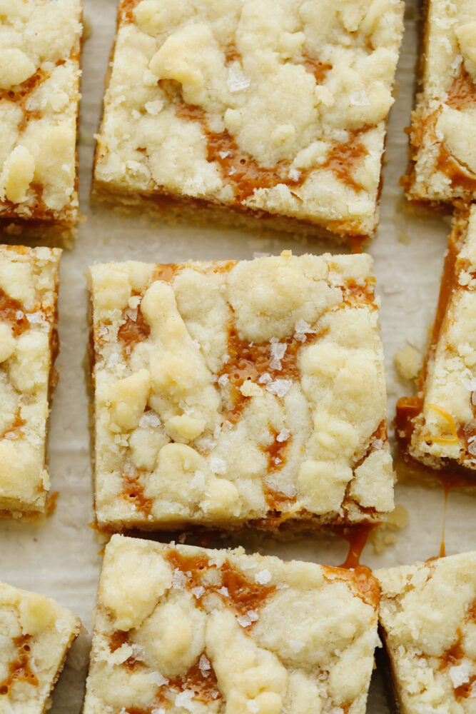 Salted caramel butter bars on a baking sheet cut up. 