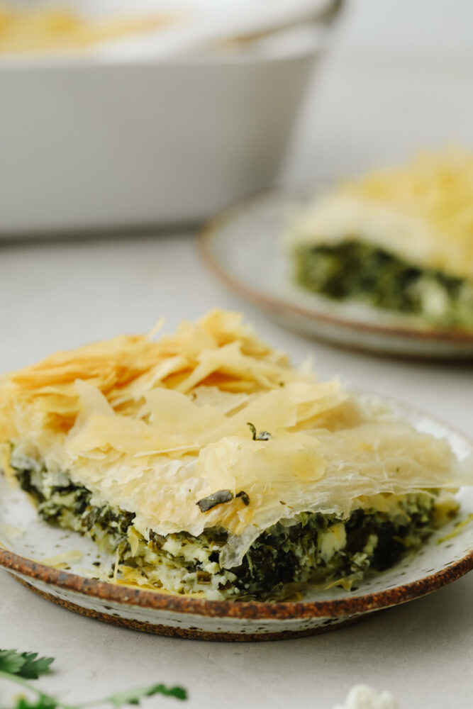 A slice of spanakopita on a plate. 