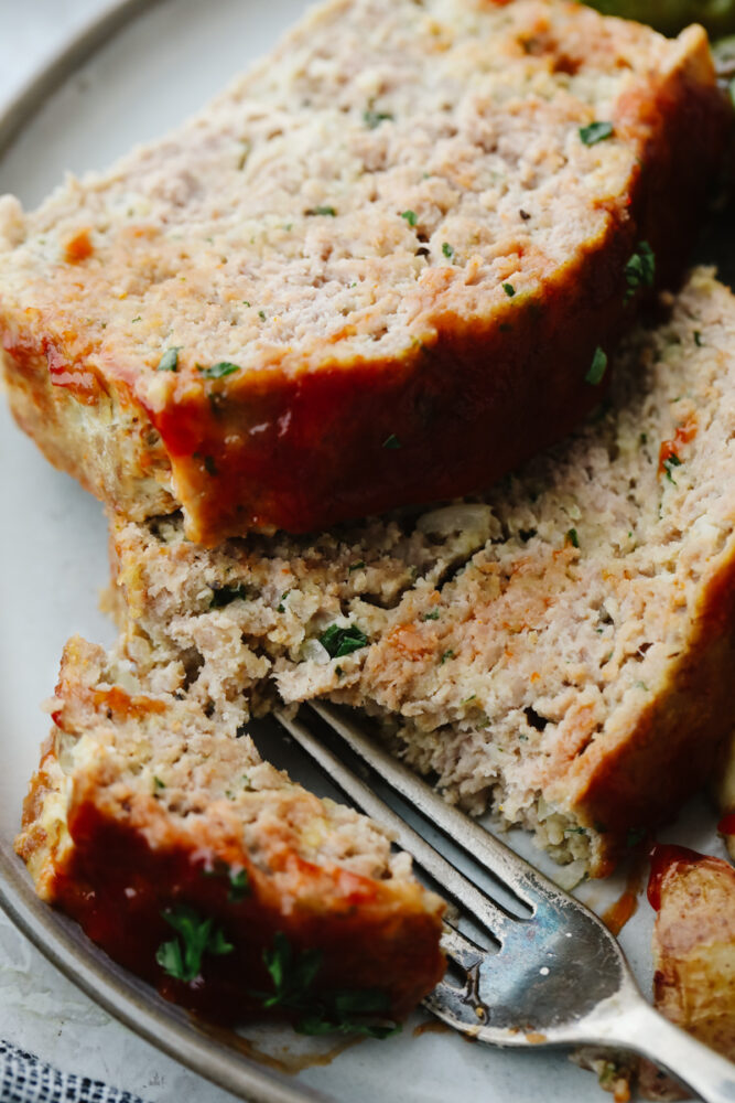 Breaking off a piece of meatloaf with a fork.