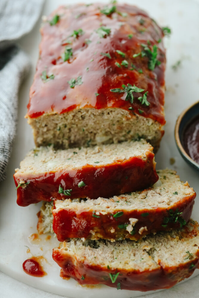 A turkey meatloaf with 3 slices cut.